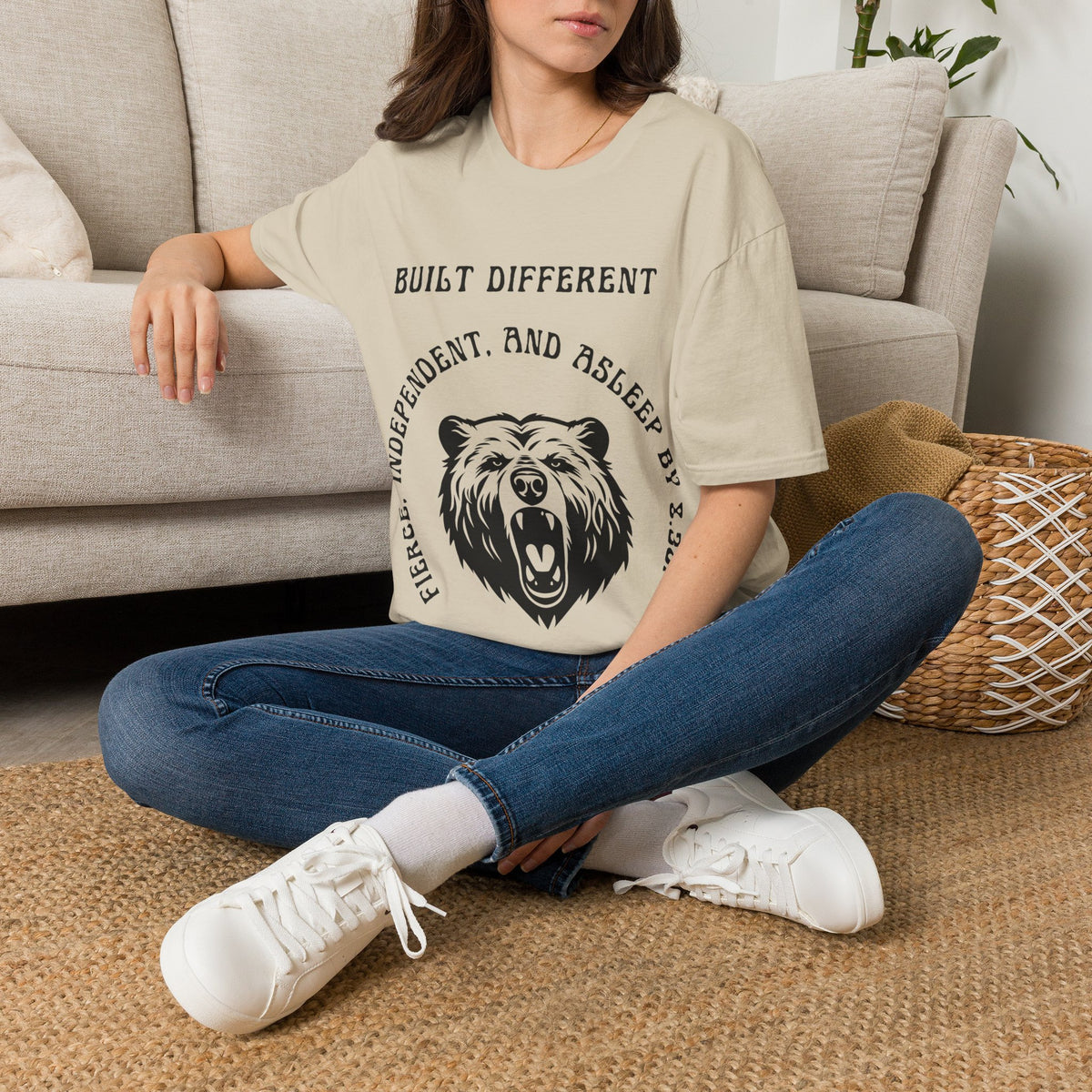 A white short-sleeve graphic t-shirt . The t-shirt features a black graphic of a roaring bear with the text 'MY BACK IF I SLEEP WRONG' and 'BUILT DIFFERENT' above it.