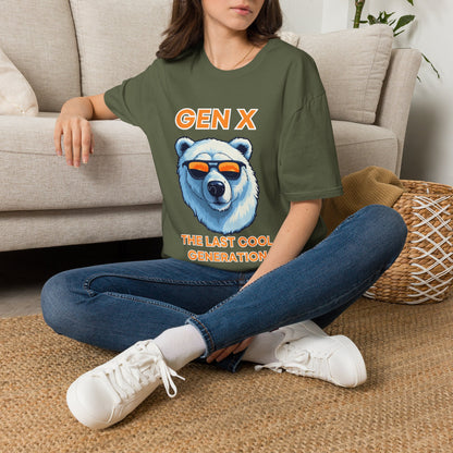 A woman sat on rug next to couch wearing a green short-sleeve graphic T-shirt, with orange text reading 'Gen x' and 'The last cool generation' a  polar bear illustration.