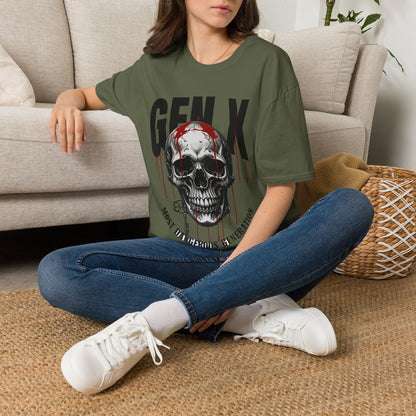 Lady wearing a green t-shirt with a skull with dripping blood and the text  'GEN X MOST DANGEROUS GENERATION' with jeans and white sneakers sitting on the floor.