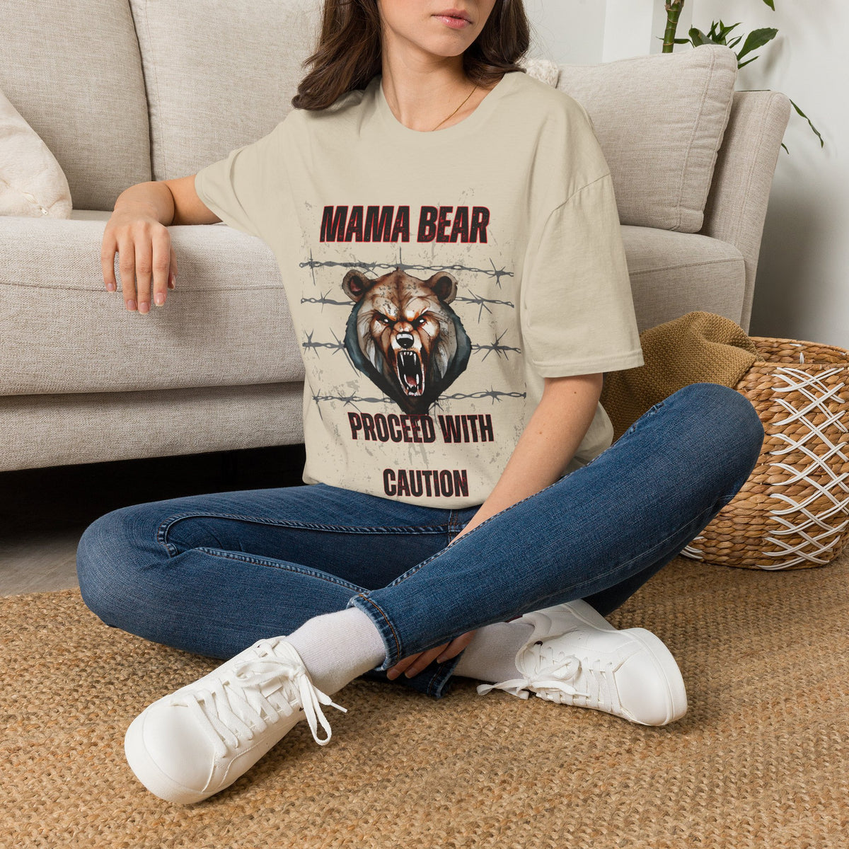 Person wearing a t-shirt with a bear graphic design sitting on the floor.