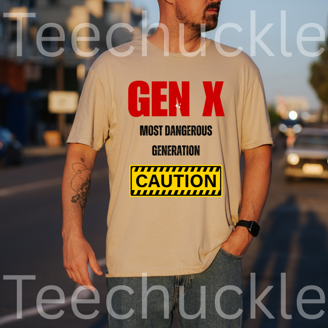 A man wearing a sand graphic t-shirt with a red and black 'GEN X MOST DANGEROUS GENERATION' print and a yellow caution box graphic. The background is a blurred street scene at sunset