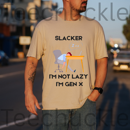 A man wearing a sand graphic t-shirt with a 'Slacker I'm Not Lazy I'm Gen X' design, standing outdoors on a street at sunset.