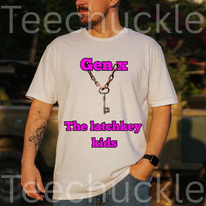 A man wearing a white graphic t-shirt with a keychain design and pink text reading 'Gen x The latchkey kids'. The background is a blurred outdoor setting.