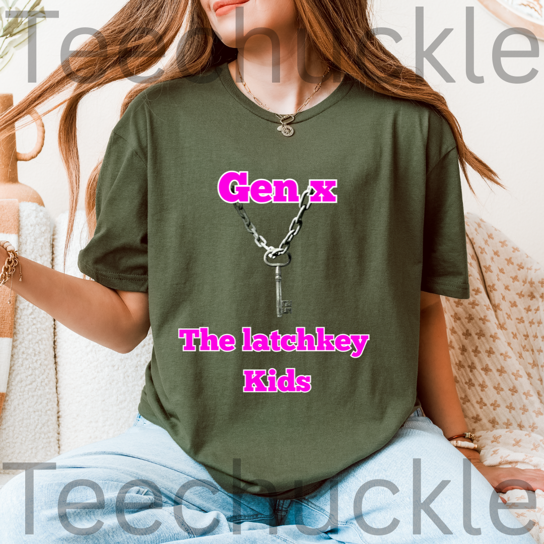 A woman wearing a green graphic t-shirt with a keychain design and the text 'Gen x The latchkey Kids' in pink. The photo is taken in a cozy indoor setting with a neutral background.