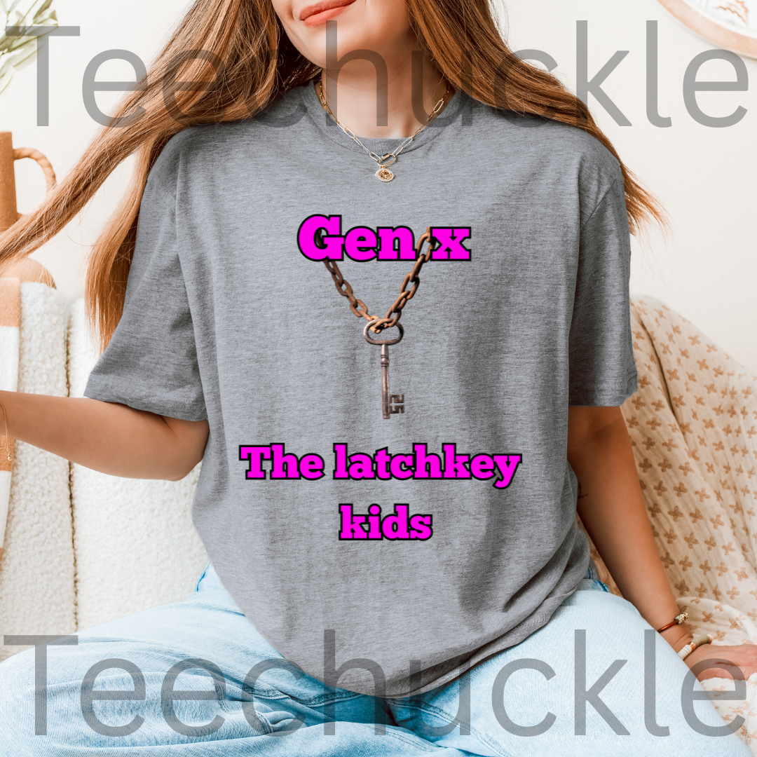 A woman wearing a gray graphic t-shirt with a graphic of a key on a chain and the text 'Gen X The latchkey kids' in pink in a cosy indoor setting in the background