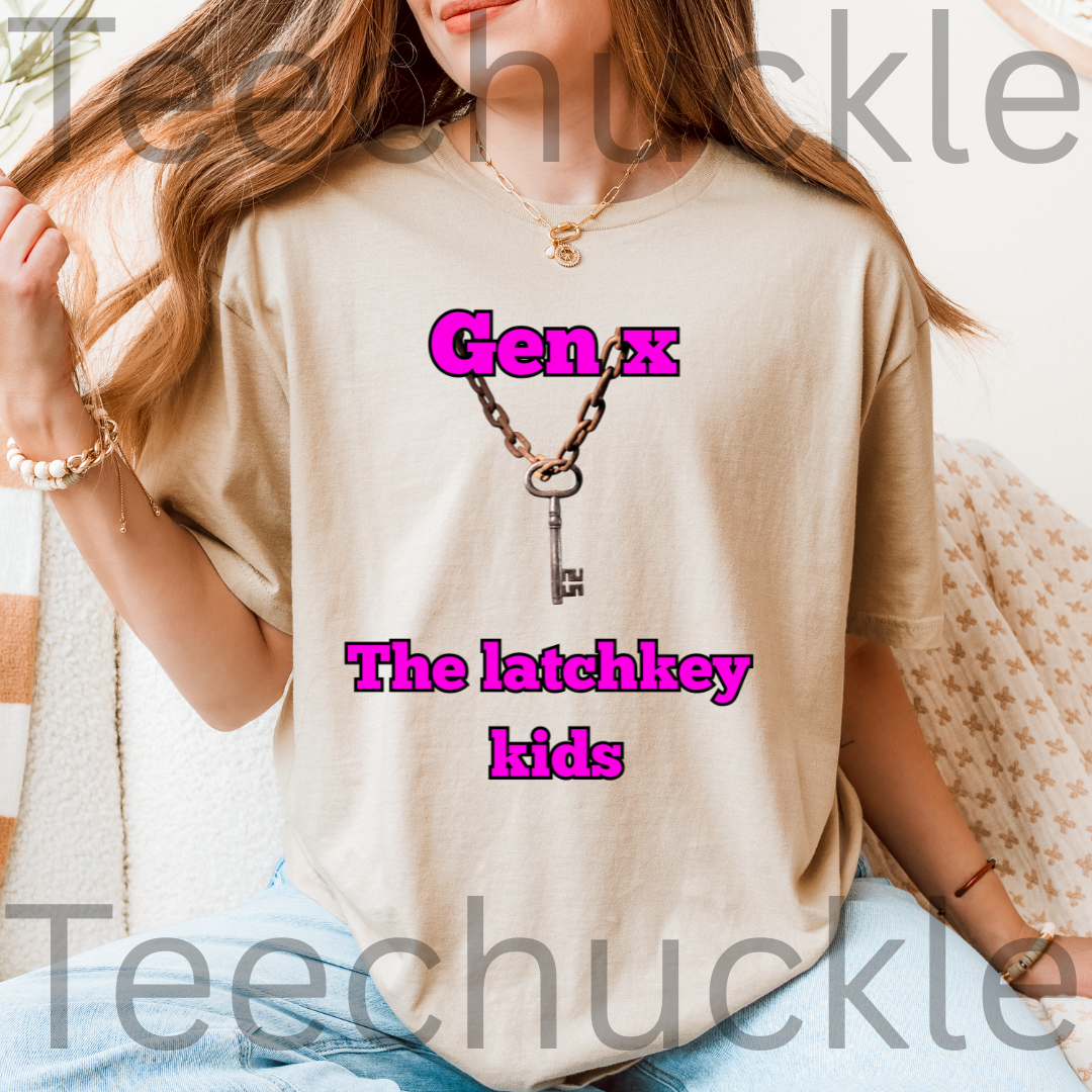 A woman wearing a sand graphic t-shirt with a vintage key necklace design and the text 'Gen X The latchkey kids' in pink in a cosy indoor scene.