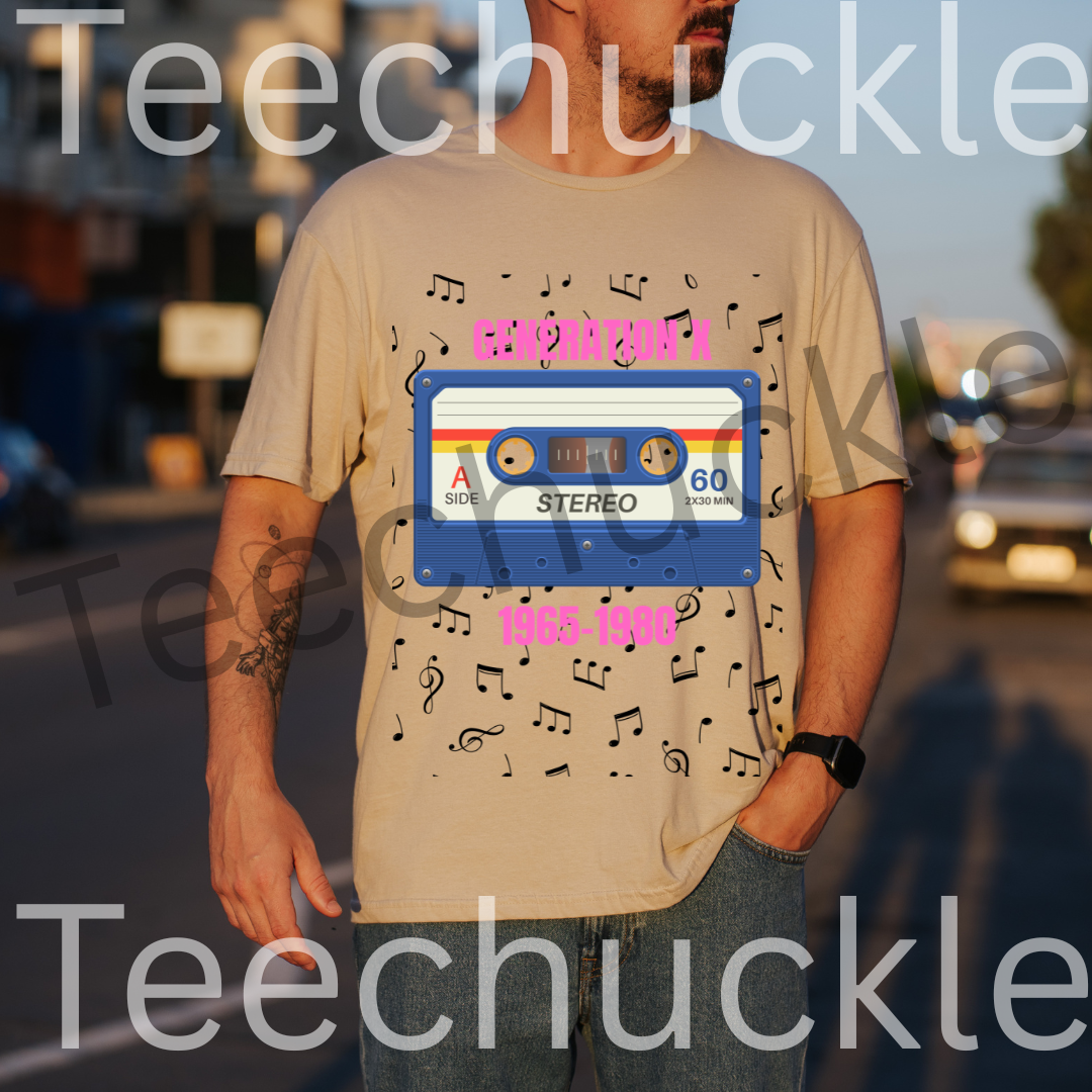 A man wearing a sand graphic t-shirt with a retro cassette tape design and musical notes, standing outdoors on a street at sunset. The t-shirt features a blue cassette graphic with pink text reading 'GENERATION X 1965-1980' and black musical notes.