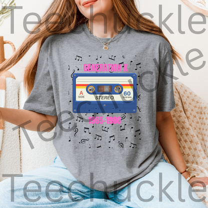 Lady wearing a gray t-shirt with a 80s style cassette tape design with pink text "GENERATION X 1965-1980" and music notes.