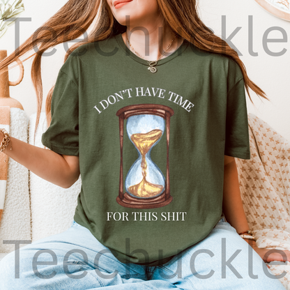 A woman wearing a green graphic t-shirt with a printed hourglass design and the text 'I DON'T HAVE TIME FOR THIS SHIT'.