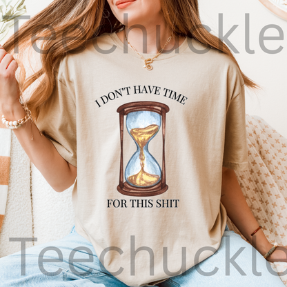 A woman wearing a sand graphic t-shirt with a humorous text print and an hourglass illustration. The text reads 'I DON'T HAVE TIME FOR THIS SHIT'.