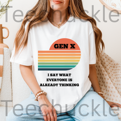 A woman wearing a white graphic T-shirt with a retro sunset design and the text 'GEN X I SAY WHAT EVERYONE IS ALREADY THINKING'.