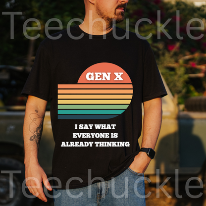 A man wearing a black graphic t-shirt with a retro sunset design and the text 'GEN X I SAY WHAT EVERYONE IS ALREADY THINKING'. The background is an outdoor setting with a blurred truck and foliage.