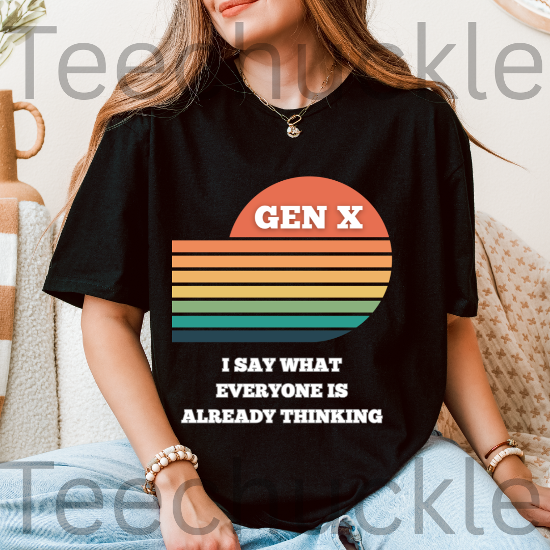 A woman wearing a black graphic T-shirt with a retro sunset design and the text 'GEN X I SAY WHAT EVERYONE IS ALREADY THINKING'.