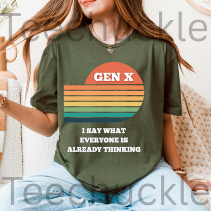 A woman wearing a green graphic t-shirt with a retro sunset design and the text 'GEN X I SAY WHAT EVERYONE IS ALREADY THINKING'.