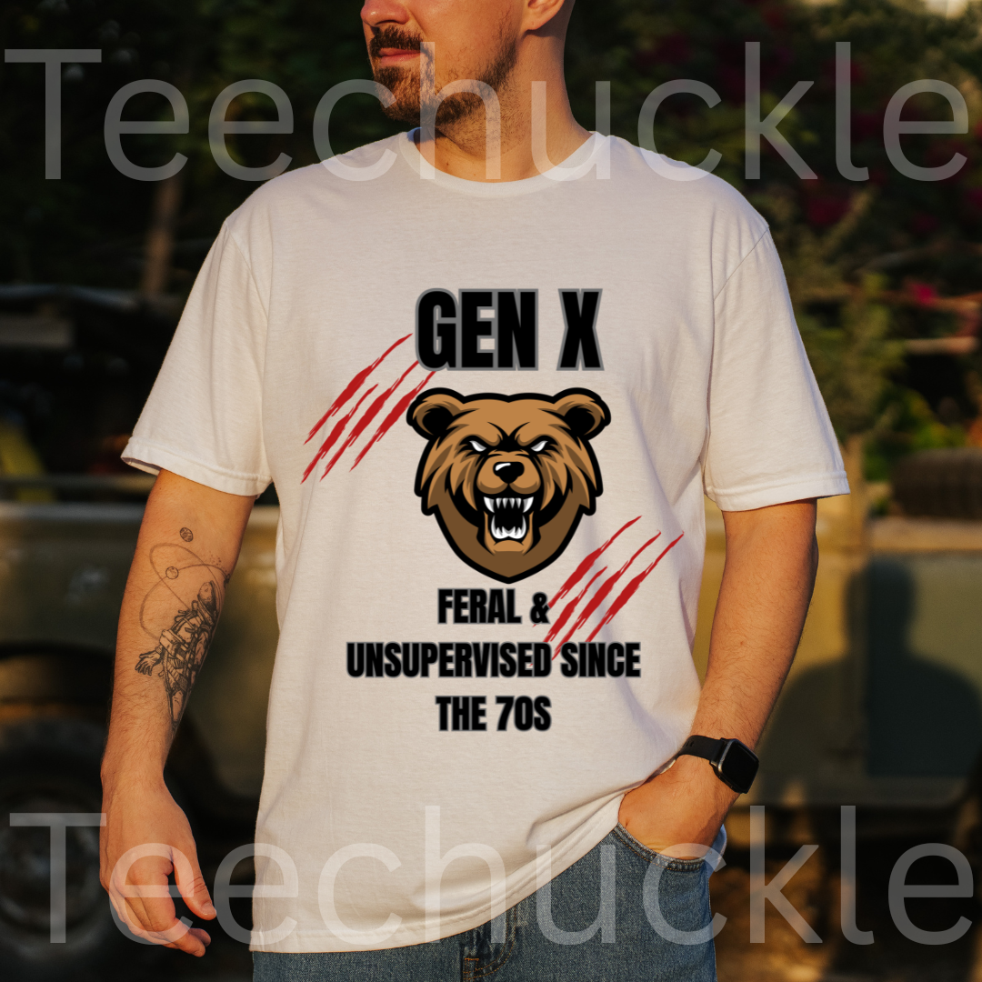 A man wearing a white graphic t-shirt with a bear head and the text 'GEN X FERAL & UNSUPERVISED SINCE THE 70S' printed on the front, set against a blurred outdoor background.