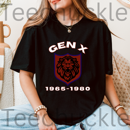 A woman wearing a black graphic T-shirt with a lion crest and the text 'GEN X 1965-1980' printed on the front, seated indoors on a couch.