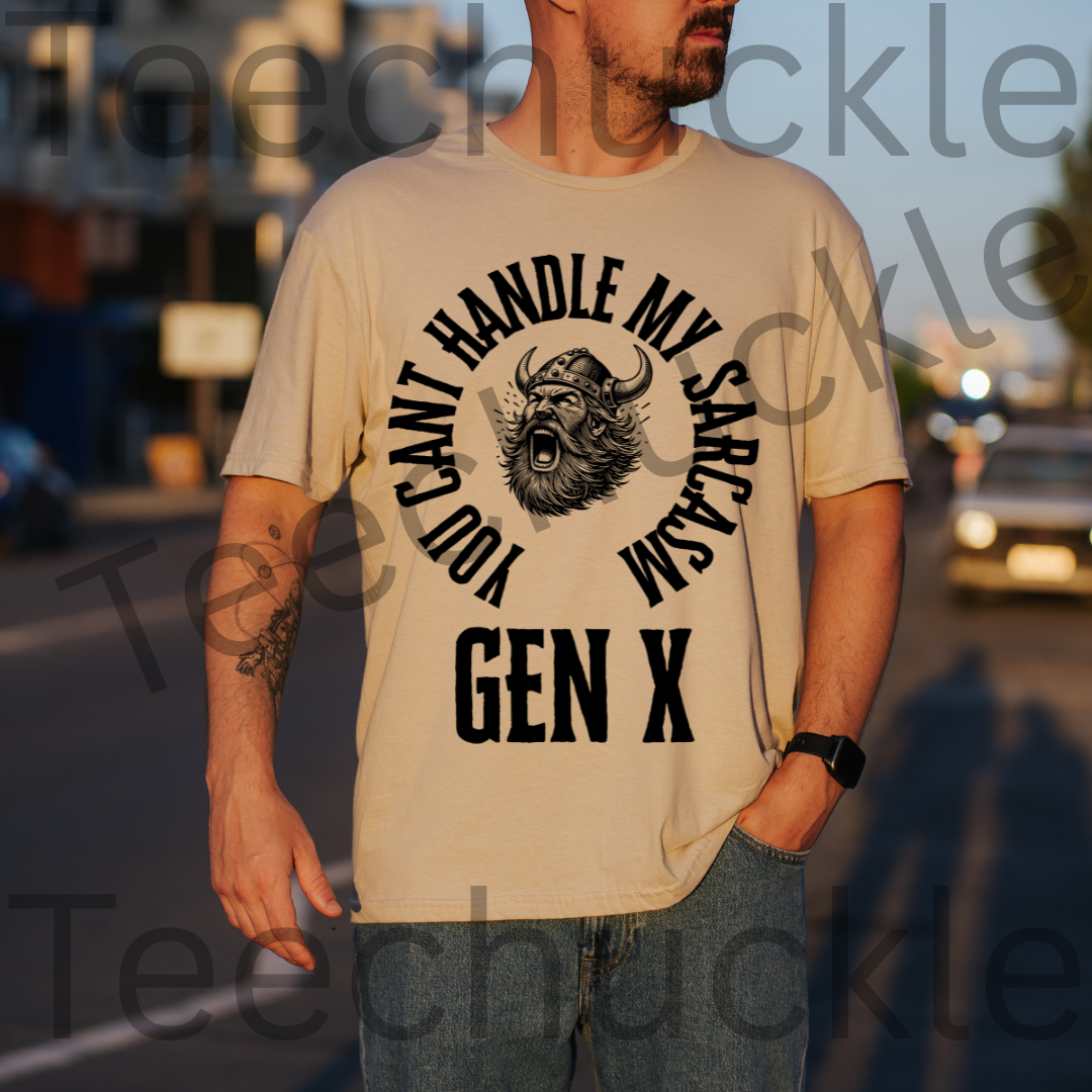 A man wearing a sand graphic t-shirt with a black print that reads 'YOU CAN'T HANDLE MY SARCASM GEN X' with a horned viking illustration, set against a blurred street background.