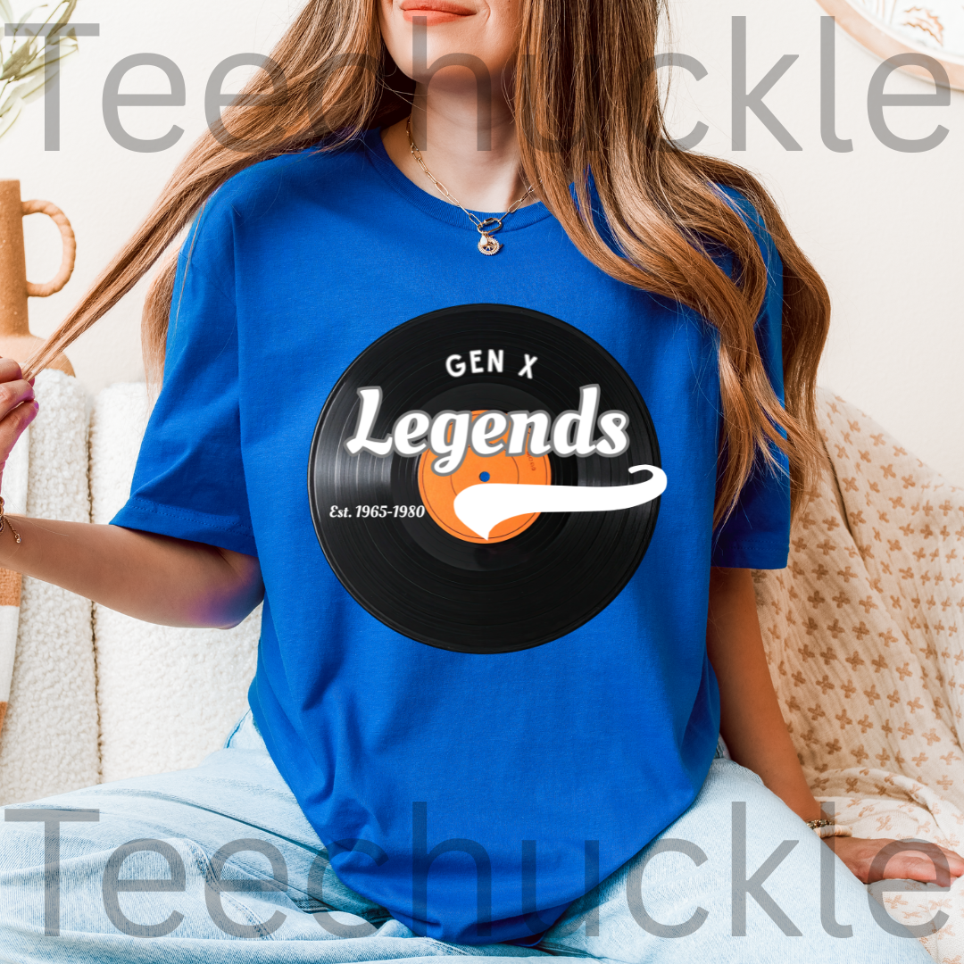 A woman wearing a bright blue graphic T-shirt with a black vinyl record design that reads 'GEN X Legends Est. 1965-1980' 