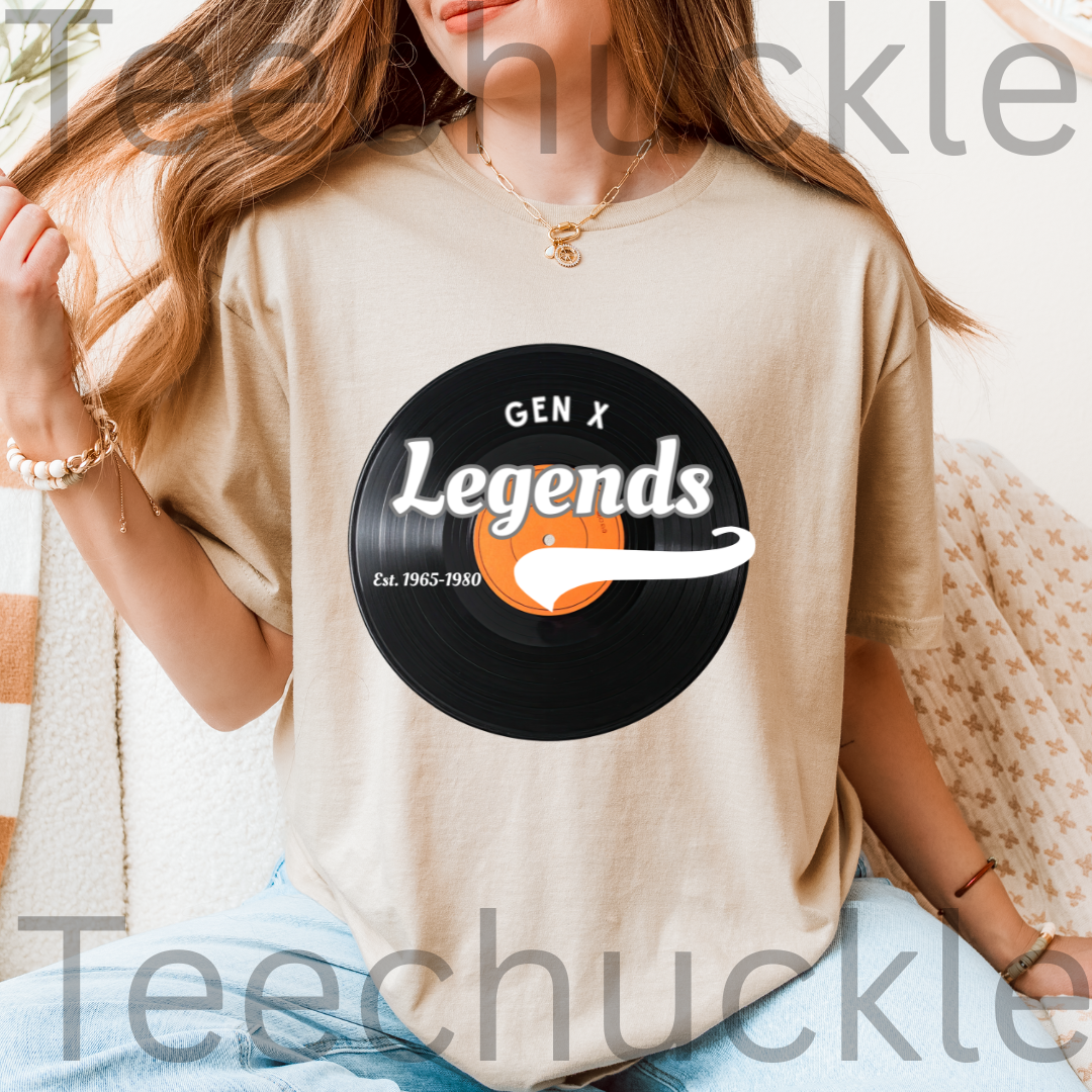 A woman wearing a sand graphic t-shirt with a black vinyl record design that reads 'GEN X Legends Est. 1965-1980' 