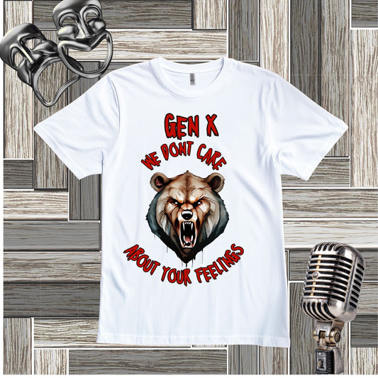 A white short-sleeve graphic t-shirt laid flat on a gray wood plank background. The shirt features a graphic of a snarling bear and text that reads 'GEN X WE DON'T CARE ABOUT YOUR FEELINGS' in red and black.