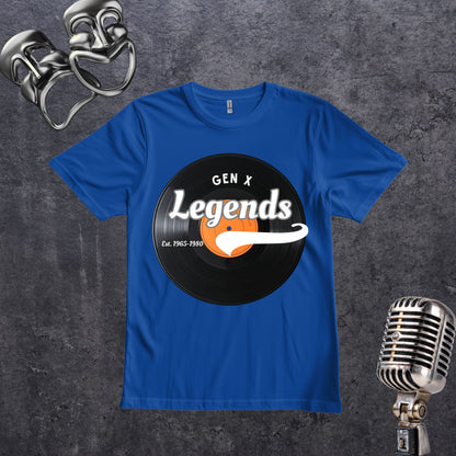 A royal blue short-sleeve t-shirt laid flat on a dark textured background, featuring a circular black vinyl record graphic with the words 'GEN X Legends' and 'Est. 1965-1990' in white and orange.