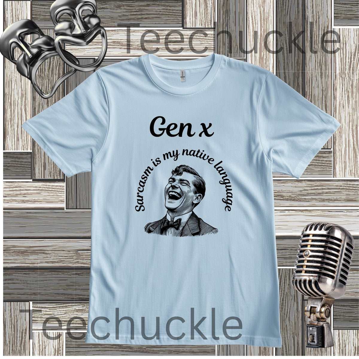 A light blue short-sleeve graphic t-shirt featuring a black illustration of a laughing man with the text 'Gen x' and 'Sarcasm is my native language' printed on the front. The shirt is displayed on a rustic wood plank background with vintage microphone and theater prop graphics