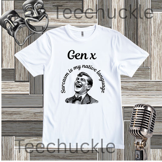 A white short-sleeve graphic T-shirt laid flat on a wood plank background, with black text reading 'Gen x' and 'Sarcasm is my native language' around a black-and-white portrait illustration. Decorative vintage theater masks and a retro microphone appear around the shirt