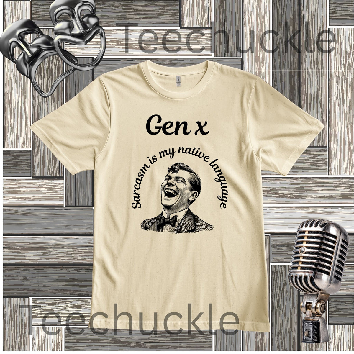 A cream-colored graphic t-shirt featuring a black print of a laughing man and the text 'Gen x' and 'Sarcasm is my native language'. The t-shirt is displayed on a gray wood panel background with vintage props including a metal microphone, a small reel-to-reel tape recorder, and a pair of theatrical masks.