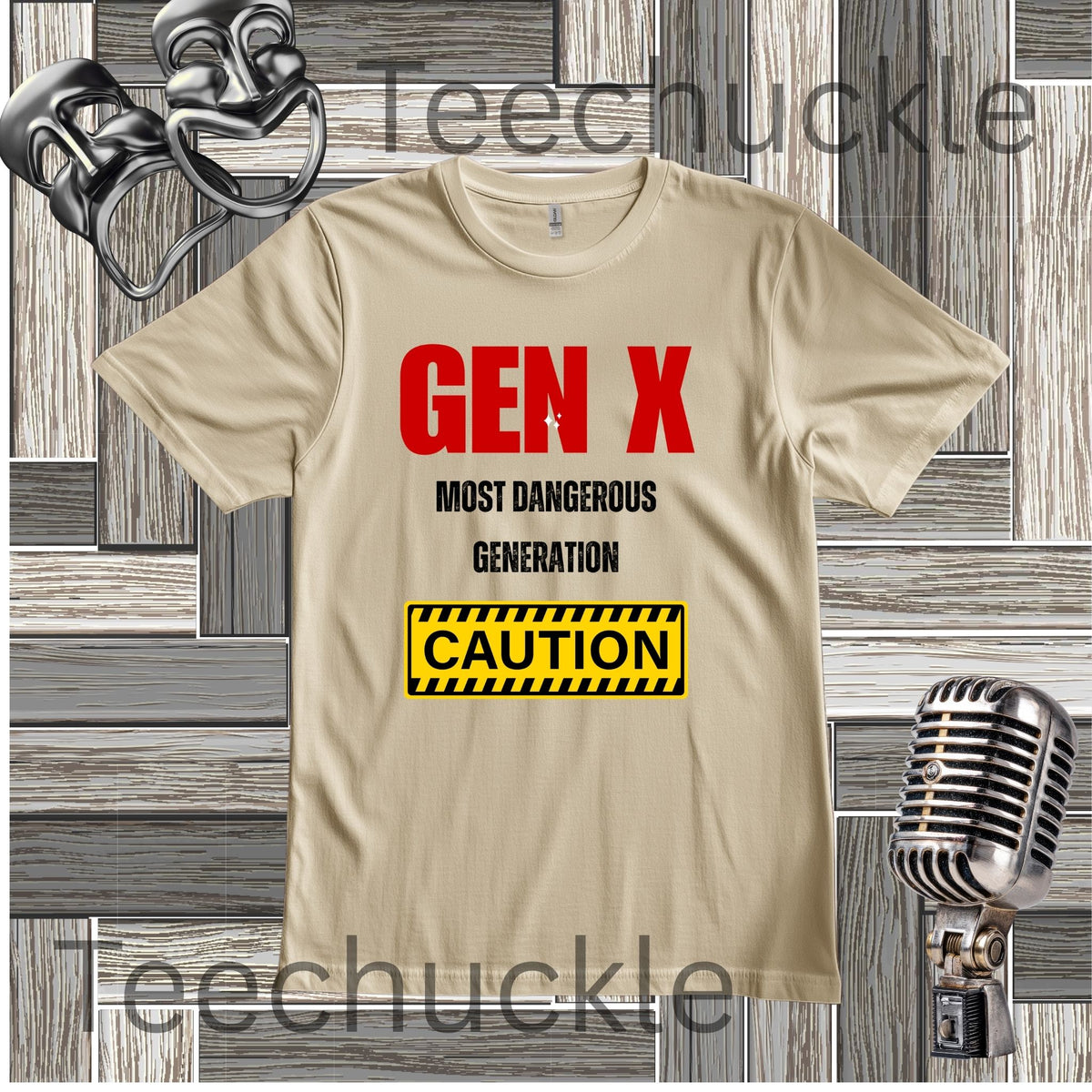 A sand graphic t-shirt featuring the text 'GEN X MOST DANGEROUS GENERATION' in red and black, with a yellow and black caution box graphic. The t-shirt is displayed on a gray wood plank background with vintage microphone and comedy masks props