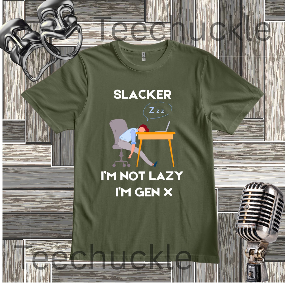 A green graphic t-shirt featuring a cartoon illustration of a person sleeping at a desk with the text 'SLACKER I'M NOT LAZY I'M GEN X'. The t-shirt is displayed on a gray wood-plank background with vintage-style microphones