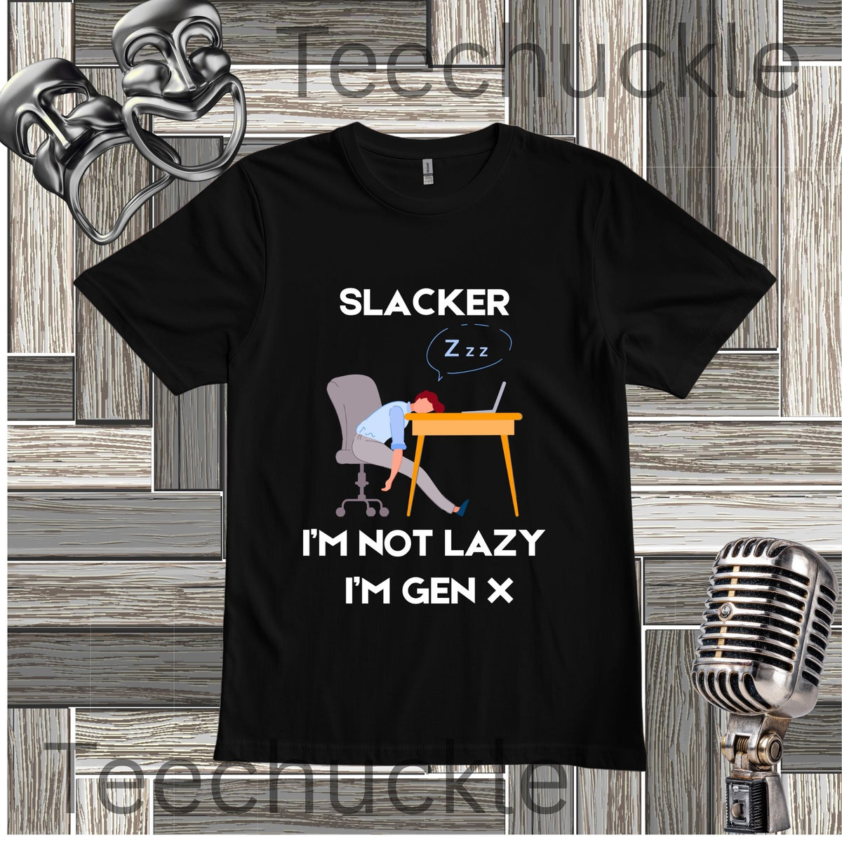 A black graphic t-shirt displayed on a gray wood-paneled background with a vintage microphone and metal headphones. The t-shirt features a cartoon illustration of a person sleeping at a desk with the text 'SLACKER I'M NOT LAZY I'M GEN X'.
