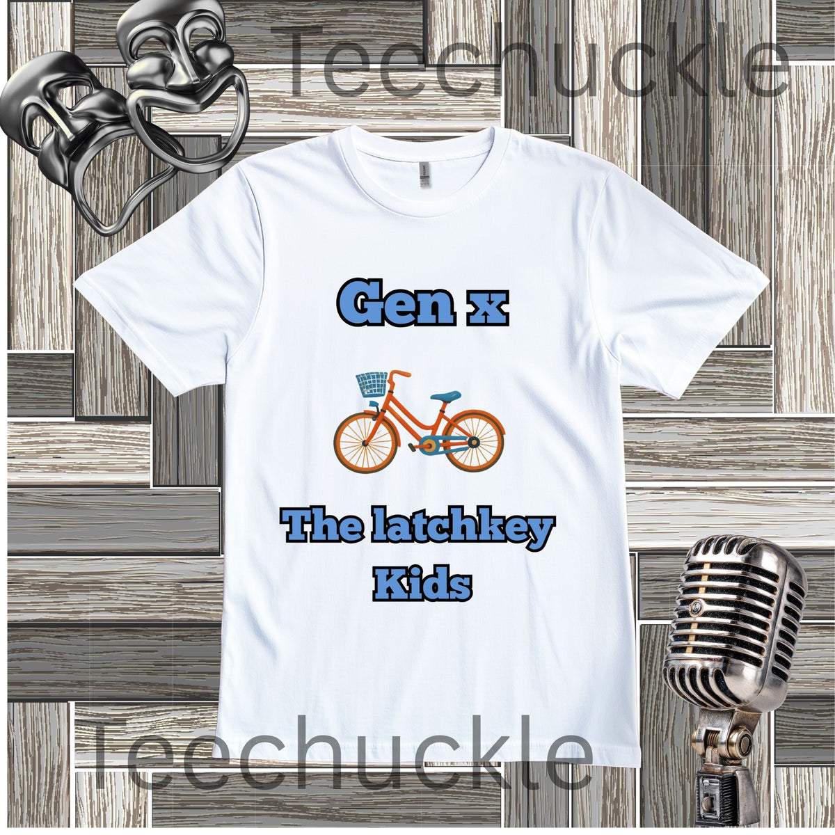 A white graphic t-shirt featuring the text 'Gen x The latchkey Kids' in blue, with an illustration of an orange bicycle in the center. The t-shirt is displayed on a gray wood panel background with vintage-style props, including a silver microphone and a metal object in the corners.