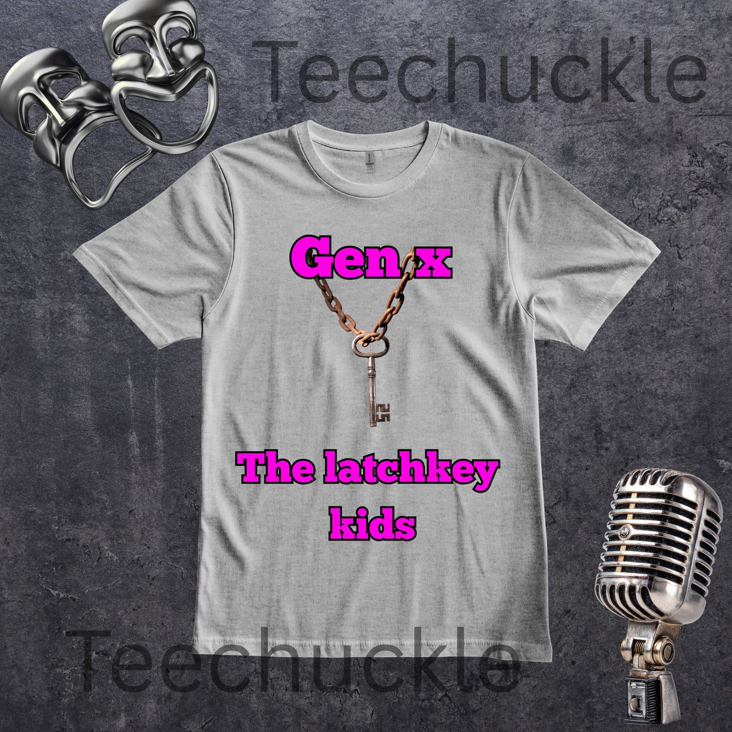 A light gray crewneck t-shirt featuring a graphic of a key on a chain with the text 'Gen x The latchkey kids' in bright pink. The t-shirt is displayed on a dark textured background with vintage silver props including a microphone, and comedy masks aroumd the shirt