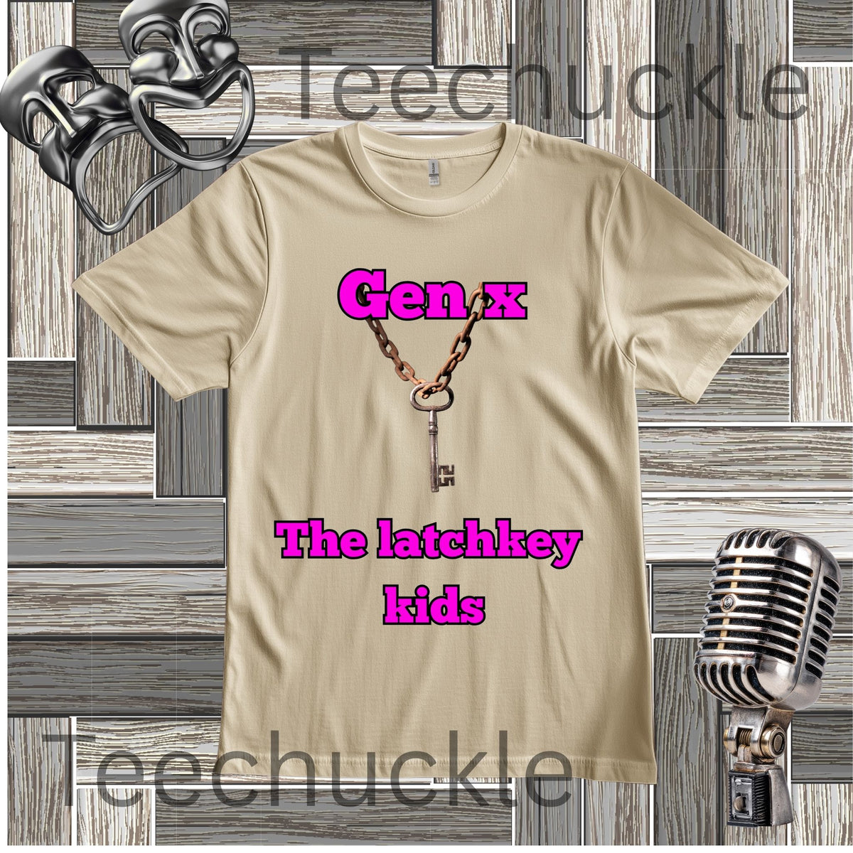 A sand graphic t-shirt featuring a key necklace design and the text 'Gen x The latchkey kids' in pink, displayed on a gray wood plank background with vintage microphone and headphones props. 
