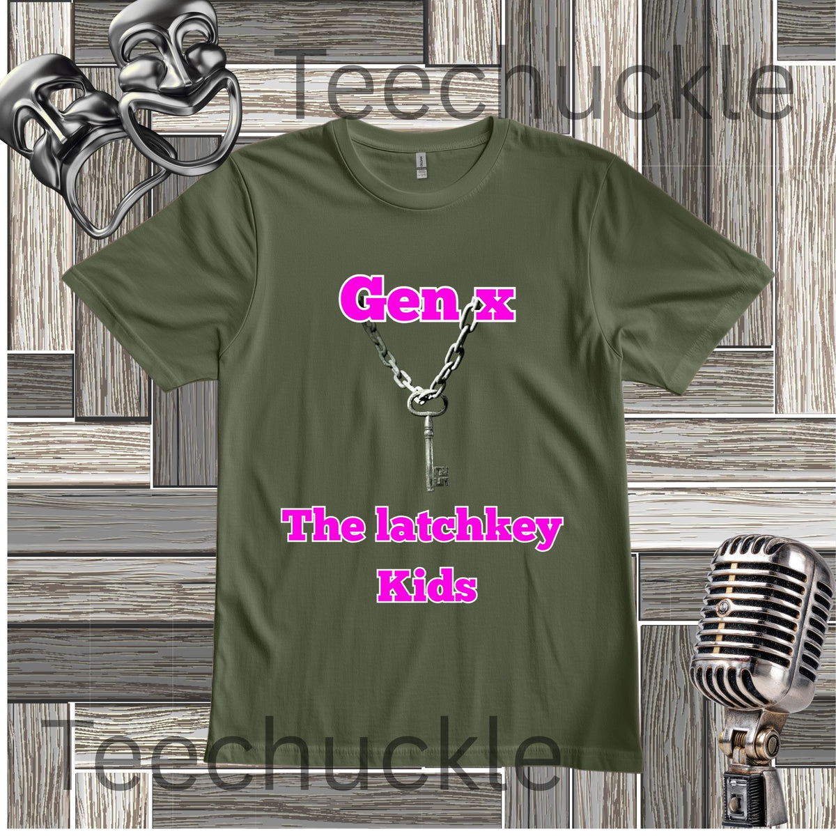 An green graphic t-shirt featuring a key necklace illustration and the text 'Gen x The latchkey Kids' in pink. The t-shirt is displayed on a gray wood-paneled background with a silver microphone and theatrical masks.