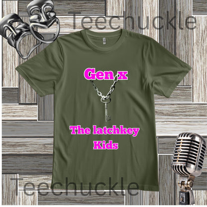 An green graphic t-shirt featuring a key necklace illustration and the text 'Gen x The latchkey Kids' in pink. The t-shirt is displayed on a gray wood-paneled background with a silver microphone and theatrical masks.