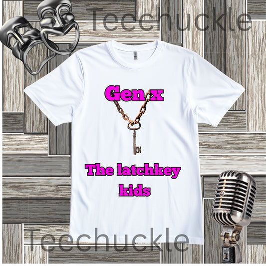 A white short-sleeve graphic t-shirt featuring a vintage key necklace design with the text 'Gen X The latchkey kids' in pink. The shirt is displayed on a gray wood-paneled background with vintage microphone and comedy mask props.