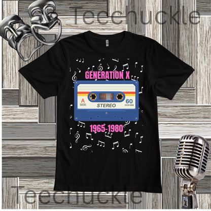 A black short-sleeve graphic T-shirt laid flat on a wood plank background, featuring a retro cassette tape design with the words 'GENERATION X' and '1965-1980' plus white musical notes along with decorative theater masks and a vintage microphone props.