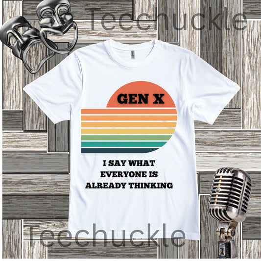 A white graphic t-shirt displayed flat against a rustic wood panel background, styled with a retro microphone. The t-shirt features a retro sunset graphic with the text 'GEN X' and 'I SAY WHAT EVERYONE IS ALREADY THINKING'.