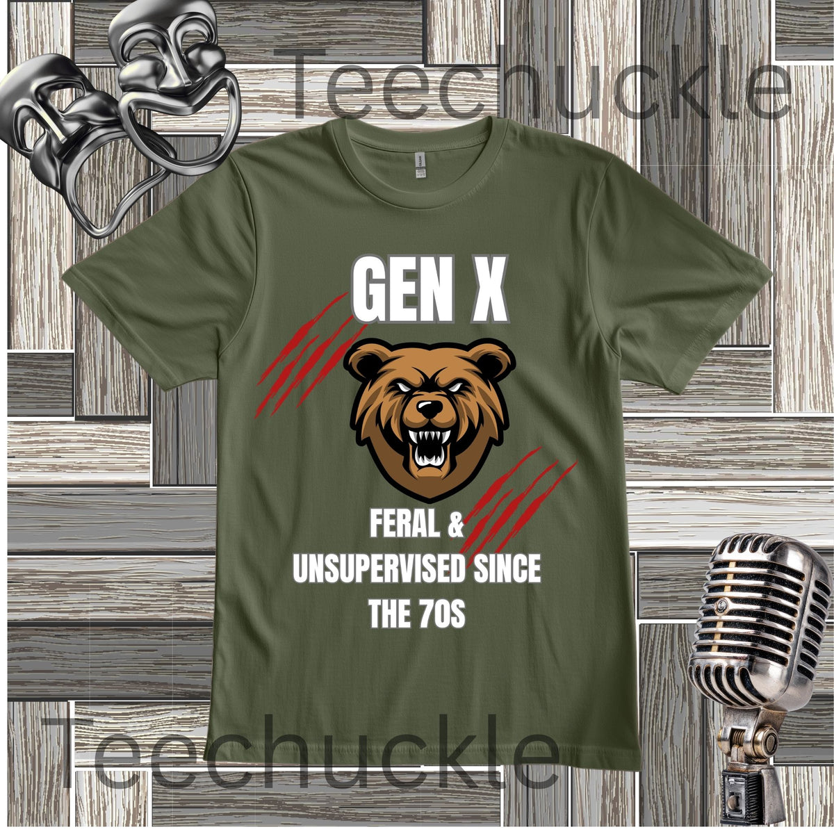 A green graphic t-shirt featuring a brown bear head illustration and the text 'GEN X FERAL & UNSUPERVISED SINCE THE 70S' with red claw marks. The t-shirt is displayed on a gray wood panel background with vintage-style microphones and a gold mask prop