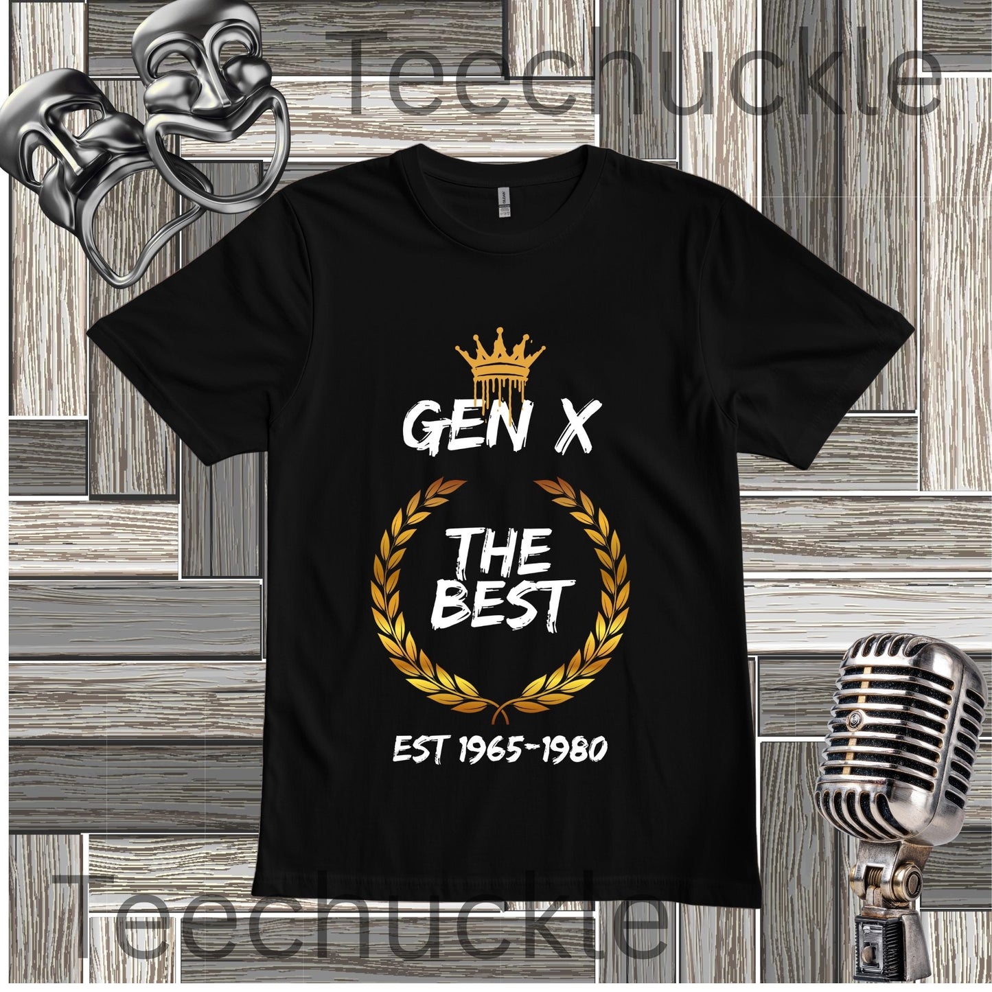 Black Gen X The Best T-shirt with crown and gold wreath graphic fkat lay on a wooden background.