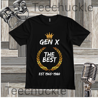 Black Gen X The Best T-shirt with crown and gold wreath graphic fkat lay on a wooden background.