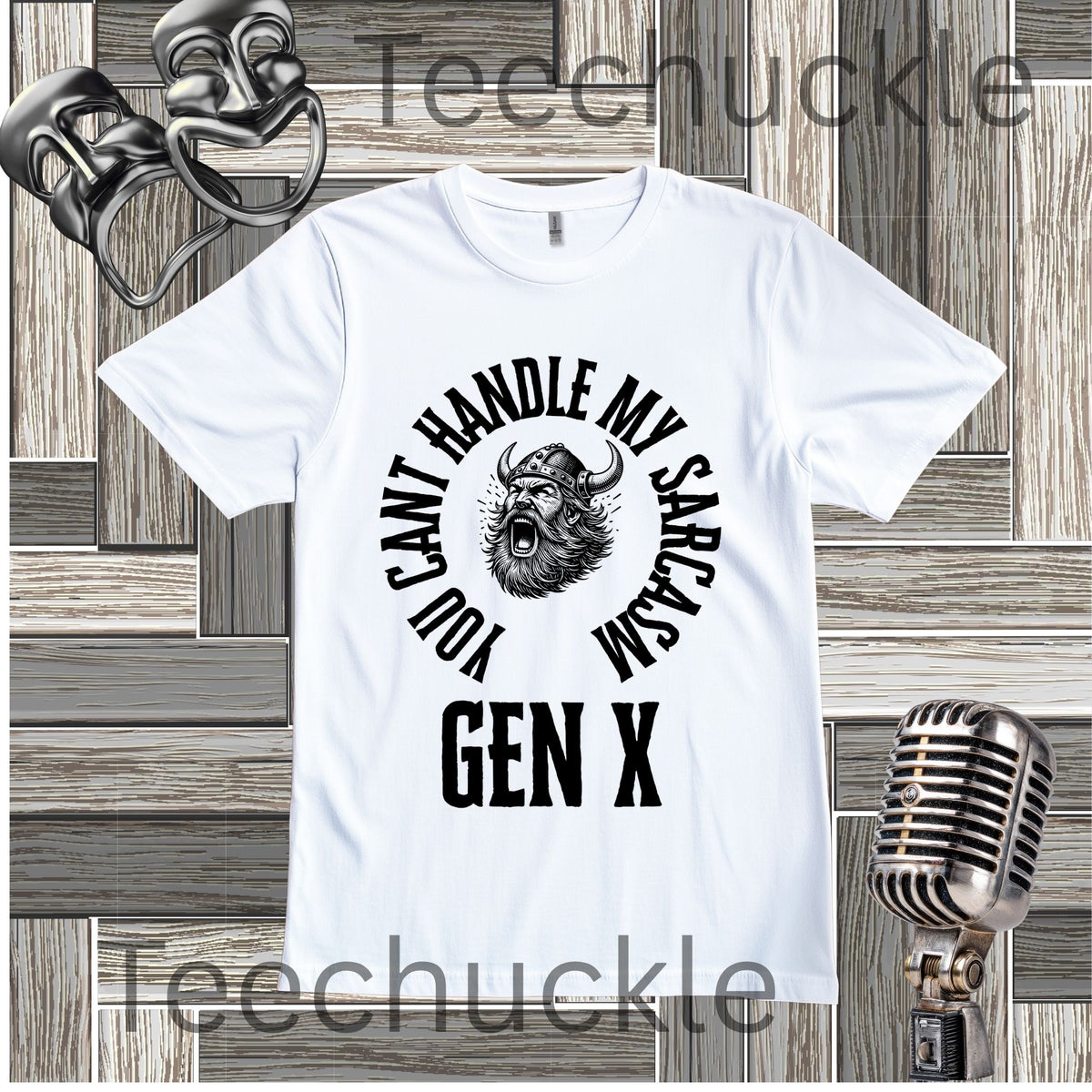 A white short-sleeve graphic t-shirt with a black circular print featuring a roaring viking man and the text 'YOU CAN'T HANDLE MY SARCASM GEN X'. The shirt is displayed on a rustic wood panel background with vintage-style props, including a silver microphone and a comedy mask