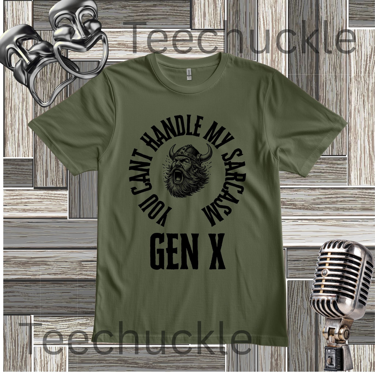 A green graphic t-shirt featuring a black circular design with a horned creature and the text 'YOU CAN'T HANDLE MY SARCASM GEN X'. The t-shirt is displayed on a gray wood panel background with vintage-style props, including a silver microphone and a comedy masks, 