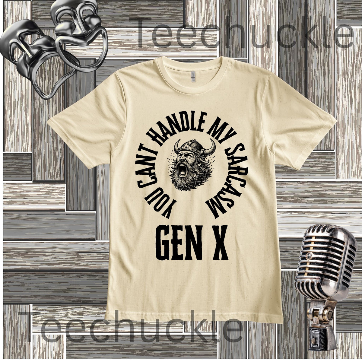 A cream short-sleeve graphic t-shirt with a black circular print featuring a roaring viking man and the text 'YOU CAN'T HANDLE MY SARCASM GEN X'. The shirt is displayed on a rustic wood panel background with vintage-style props, including a silver microphone and a comedy mask
