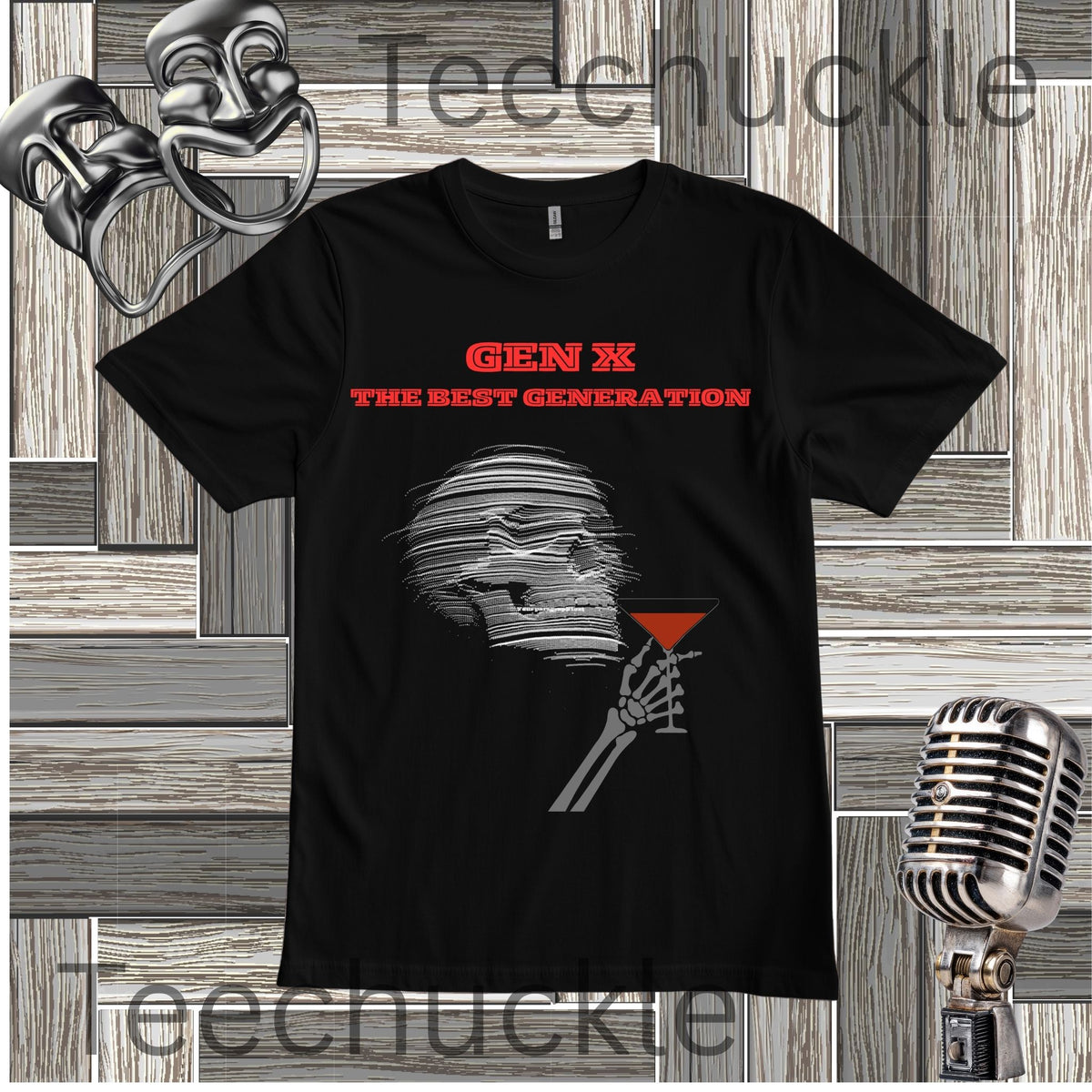 A black short-sleeve graphic T-shirt laid flat on a wood plank background, featuring red text reading 'GEN X THE BEST GENERATION' above a gray illustrated figure holding a red martini glass. Decorative props including a mask, vintage microphone, and theatrical masks appear around the shirt