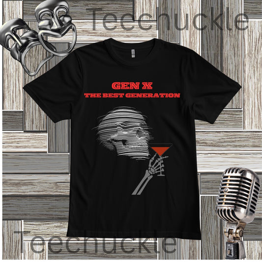 A black short-sleeve graphic T-shirt laid flat on a wood plank background, featuring red text reading 'GEN X THE BEST GENERATION' above a gray illustrated figure holding a red martini glass. Decorative props including a mask, vintage microphone, and theatrical masks appear around the shirt