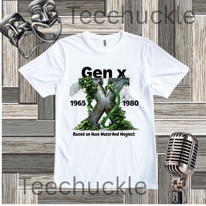 A white graphic t-shirt featuring the text 'Gen x 1965-1980 raised on hose water and neglect' in black, with an illustration of a metalic X with foliage and garden hose in the center. The t-shirt is displayed on a gray wood panel background with vintage-style props, including a silver microphone and a metal object in the corners.