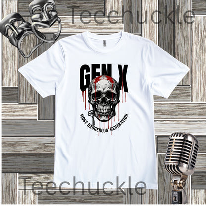 A white short-sleeve graphic T-shirt laid flat on a wood plank background, featuring a large skull and black text reading 'GEN X' with red dripping accents and the phrase 'MOST DANGEROUS GENERATION.' Decorative microphone and comedy masks props appear around the shirt.