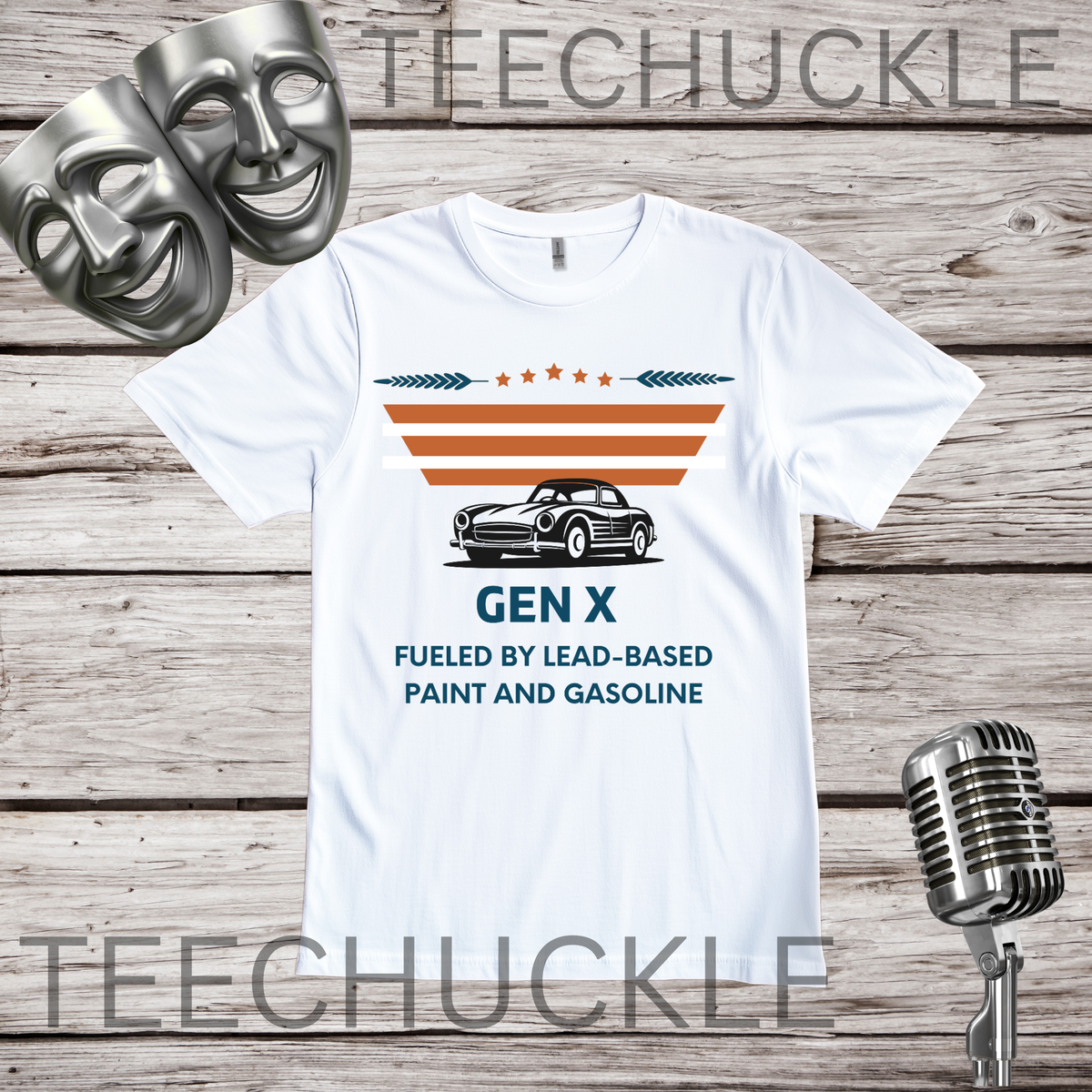 A white graphic t-shirt displayed flat on a rustic wood background, flanked by two silver comedy masks on the left and a vintage silver microphone on the right. The t-shirt features a retro design with the text 'GEN X FUELED BY LEAD-BASED PAINT AND GASOLINE' and an illustration of a classic car under orange and white stripes.